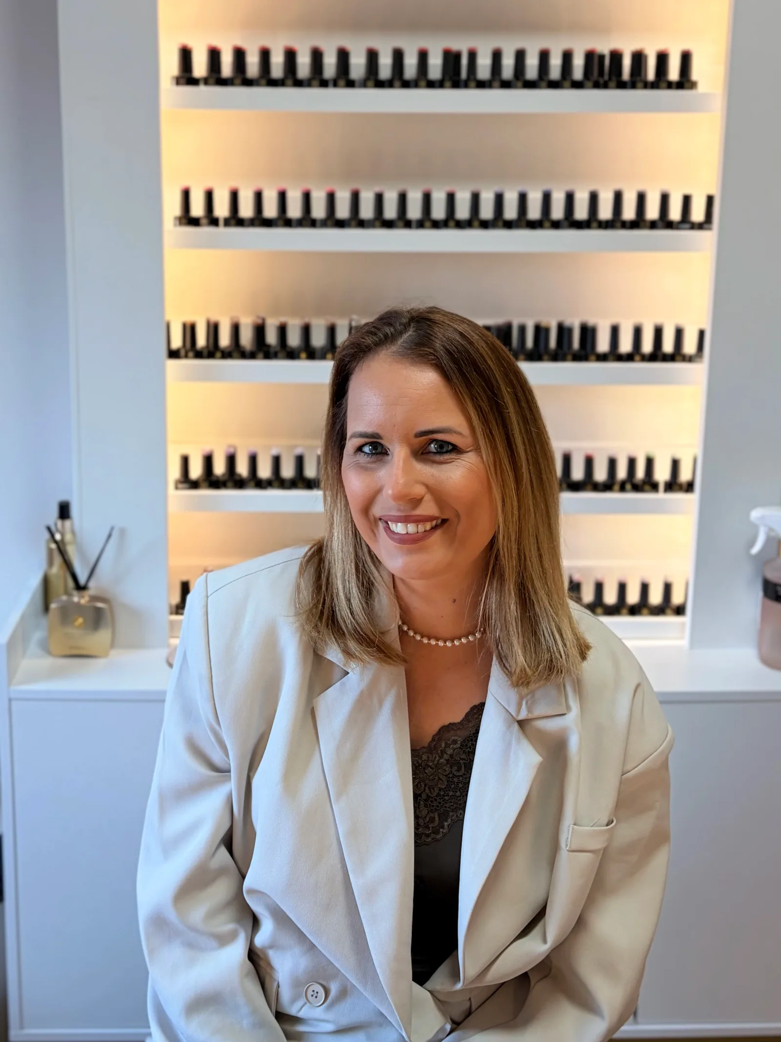 Priscilla, eigenaresse van PR Studio, in haar studio voor de verlichte wand met gellakken
