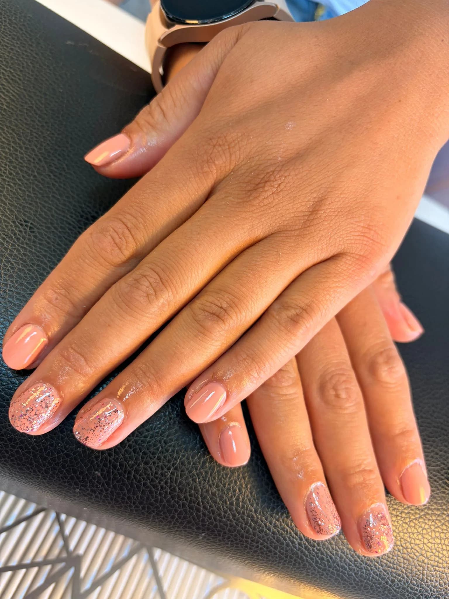 Hand met een zachte roze manicure op een wit doek