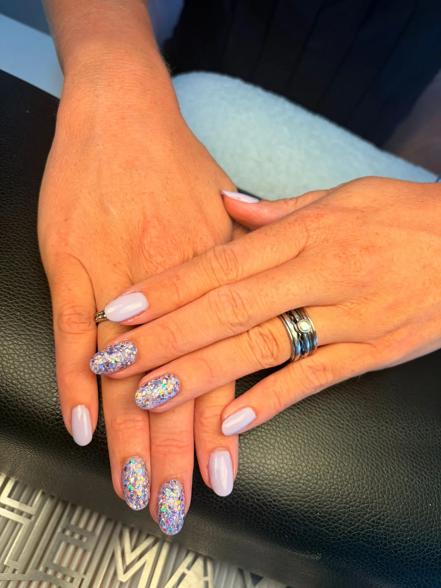 Handen met een diep taupekleurige manicure op blushkleurig satijn